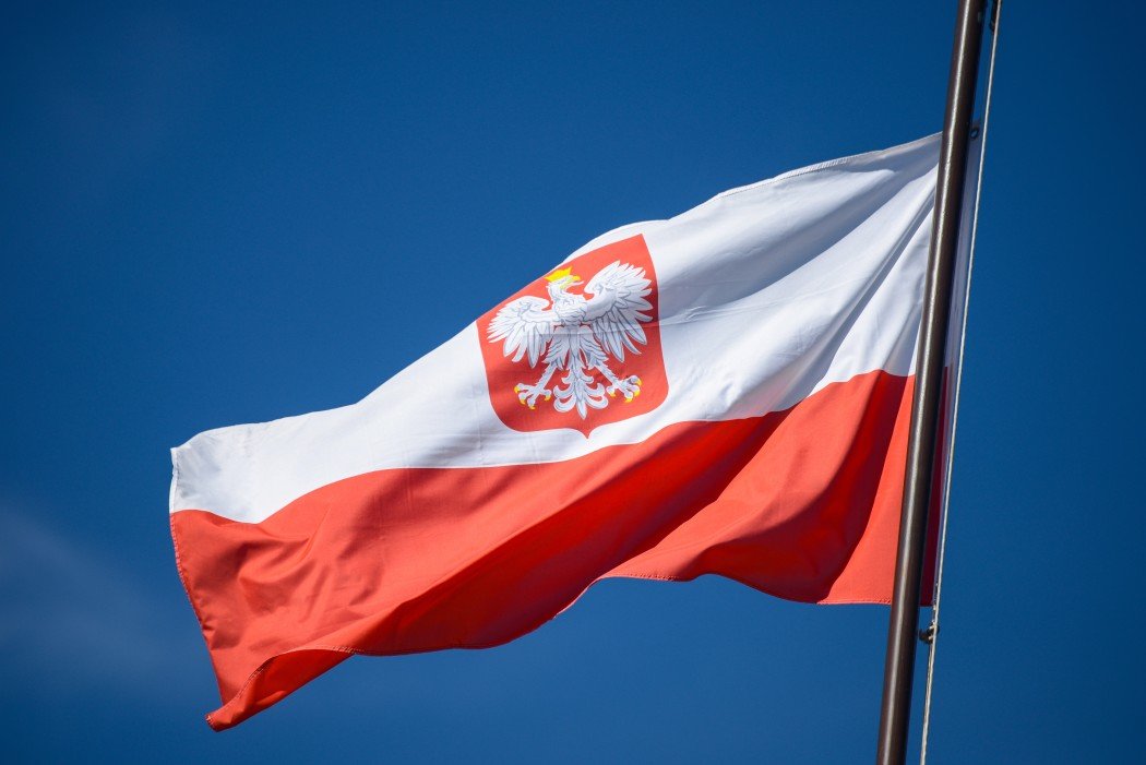 the-state-flag-of-poland-with-the-emblem-of-the-republic-of-poland-on-a-background-of-blue-sky-in-the_t20_E4amRX.jpg